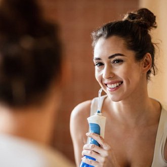 Person using water flosser at home