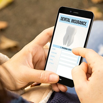 Patient looking at dental insurance form on phone outside