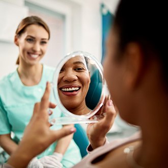 Patient smiling at reflection in treatment chair