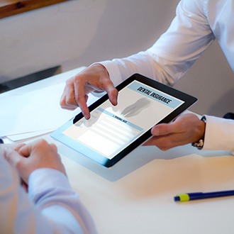 Fingers on digital tablet showing dental insurance