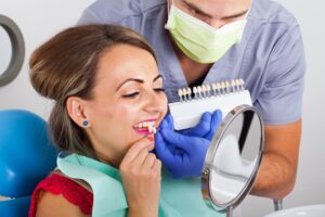 Dentist and patient trying different shades of veneers.